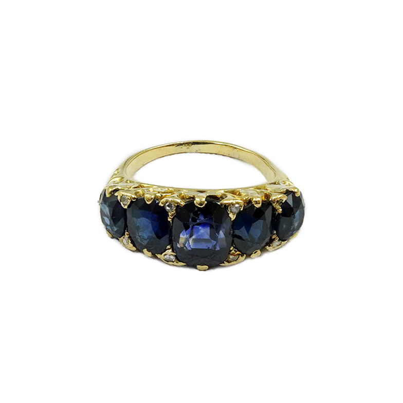 An Edwardian gold and graduated five stone oval cut sapphire set half hoop ring